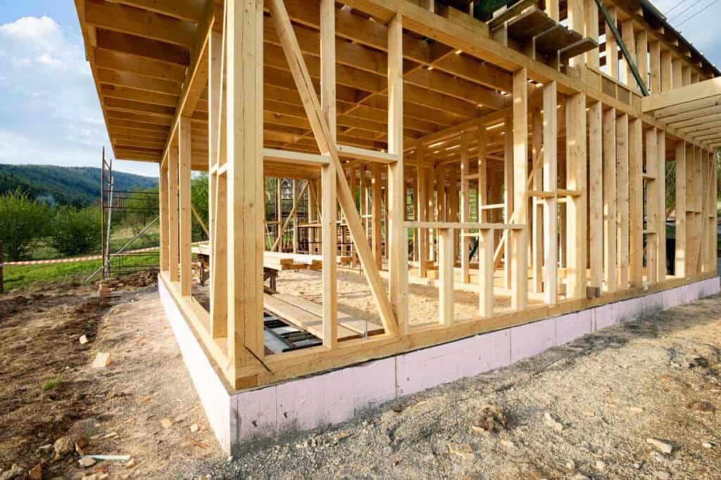 Pressure-treated wood framing for house construction at a building site, highlighting construction services.
